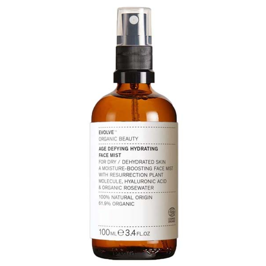 En brun flaske mærket "Evolve Age Defying Hydrating Face Mist 100 ml" med en pumpe spray top. 100 ml flasken, som er 61,9 % økologisk, er specielt udformet til tør og dehydreret hud, der giver essentiel hydrering og foryngelse.