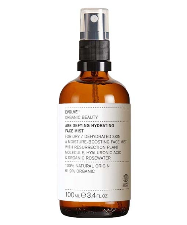 En brun flaske mærket "Evolve Age Defying Hydrating Face Mist 100 ml" med en pumpe spray top. 100 ml flasken, som er 61,9 % økologisk, er specielt udformet til tør og dehydreret hud, der giver essentiel hydrering og foryngelse.