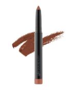 En mørkebrun læbestift, mærket "IUSKIN BEAUTY," med en matchende farveudtværing bagved, fra Glo Beauty Time To Shine - Warm Collection.