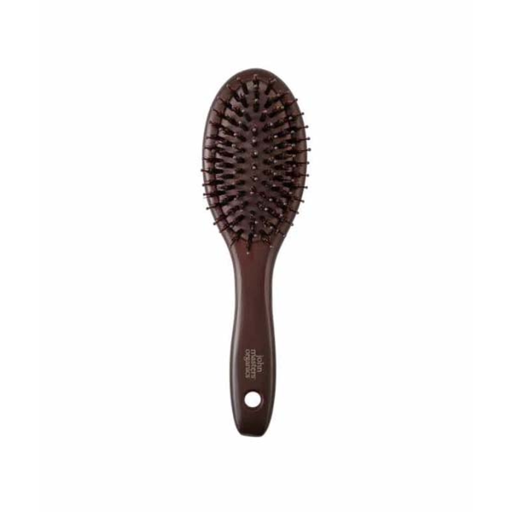 John Masters Organics Combo Paddle Brush - Mini er en brun hårbørste med et ovalt hoved og børstehår, med et hul i håndtaget til ophængning.